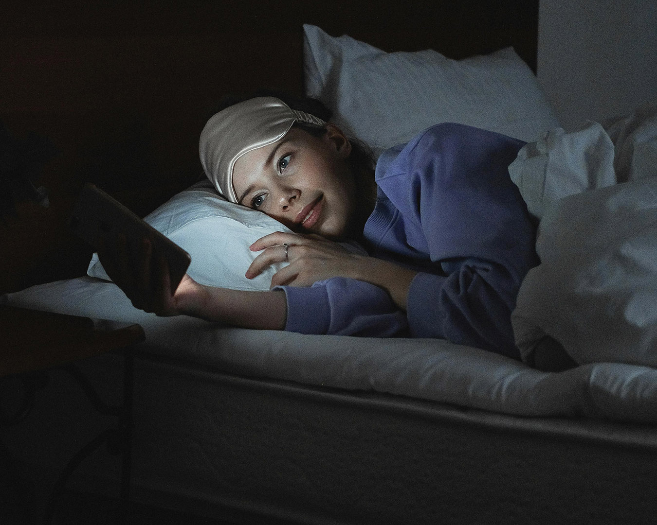 Woman Lying on Bed while Using iphone